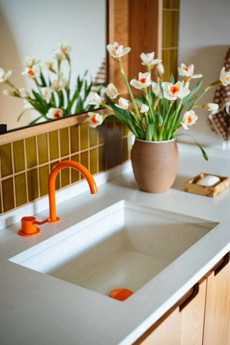 Hormigón blanco con grifería naranja