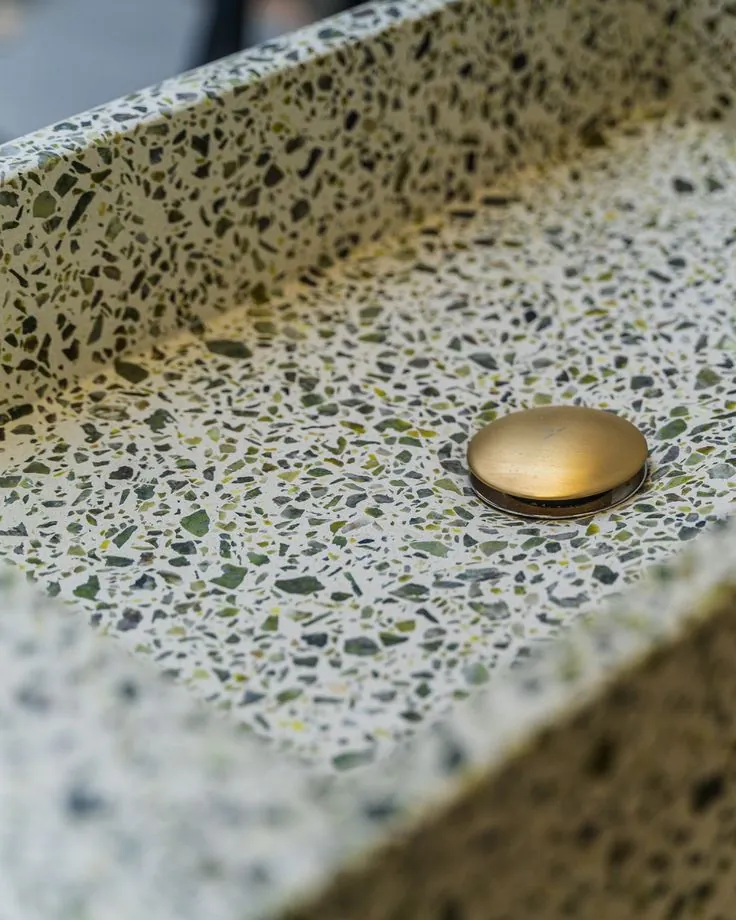 Detalle de terrazo verde con desagüe de latón