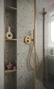 Ducha de terrazo gris con grifería de latón